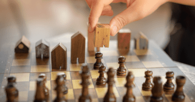 insights_general_person playing chess with wooden houses